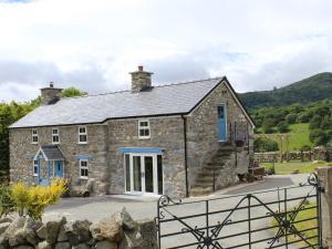 a stone cottage with blue doors and a gate at 3 Bed in Conwy 80476 in Caerhûn