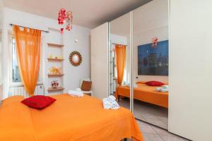 Duas camas num quarto com lençóis cor-de-laranja em LA TERRAZZA SULL'INSENATURA em Santa Teresa Gallura