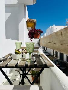 una mesa de madera en un balcón con jarrones en Apartamento Gades Conil C, en Conil de la Frontera