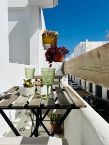 a wooden table on a balcony with vases on it at Apartamento Gades Conil C in Conil de la Frontera