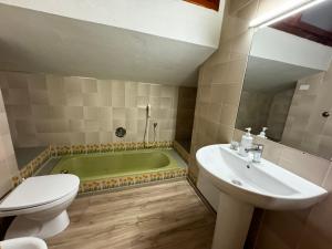 La salle de bains est pourvue d'une baignoire, d'un lavabo et de toilettes. dans l'établissement Art Villa del Poggio, à Capoterra