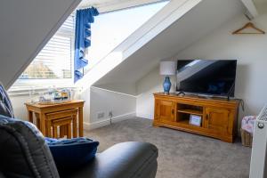 sala de estar con TV y sofá en Coast Guest House en Whitby