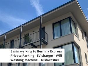 蒂拉诺Bernina Suites - vicino al Bernina Express的一座建筑,上面有标志,上面写着步行到过月球的快速私人停车场