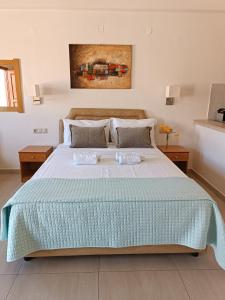 a bedroom with a bed with two trays on it at Superior Savvas Apartments by the sea in Agia Pelagia