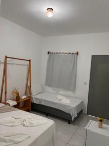 a room with two beds and a mirror at Mara Jeri Pousada in Jericoacoara