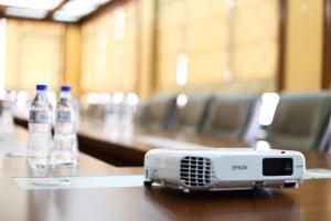 a projector on a table with bottles of water at Arber Hotel in Tirana
