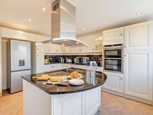 a kitchen with white cabinets and a black counter top at 5 Bed in Dovedale 90574 in Ilam