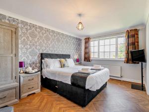 una camera con un grande letto e una televisione di 5 Bed in Dovedale 90574 a Ilam