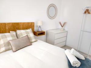 um quarto com uma cama branca e um espelho em La Parada Beach em Torre de Benagalbón