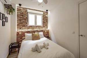 um quarto com uma parede de tijolos e uma cama em Apartamentos Santiago Cordero em Madri
