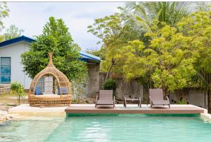 a bird cage and two chairs next to a swimming pool at Whale Fantasy in Santander