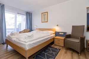 キュールングスボルンにあるYachthafenresidenz-Wohnung-5102-806のベッドルーム1室(ベッド1台、椅子、窓付)