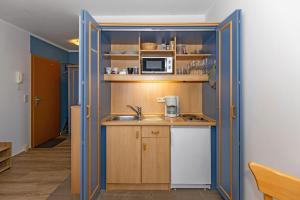a small kitchen with a sink and a microwave at Yachthafenresidenz-Wohnung-5102-806 in Kühlungsborn