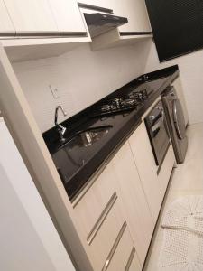 a kitchen with a sink and a stove at Apartamento com otima localizacao em Itajai SC in Itajaí