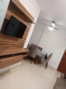 a living room with a tv and a table and chairs at Apartamento com otima localizacao em Itajai SC in Itajaí