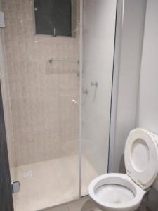 a bathroom with a toilet with a glass shower stall at Apartamento com otima localizacao em Itajai SC in Itajaí