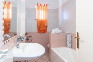 a bathroom with a sink and a toilet and a tub at LA TERRAZZA SULL'INSENATURA in Santa Teresa Gallura +7 photos