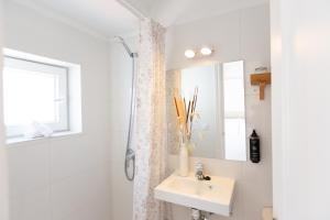 a white bathroom with a sink and a mirror at Hostal Boutique La Malagueña - Only Adults in Estepona