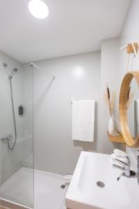 uma casa de banho branca com um lavatório e um chuveiro em Hostal Boutique La Malagueña - Only Adults em Estepona