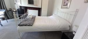 a bedroom with a white bed with a blanket at Large, Private Ensuite, Bay Window Room. in Sheffield