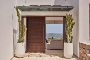 a living room with a wooden door and cactus at Elounda White Pearl Villa in Agios Nikolaos