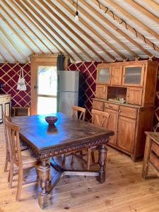 a wooden table in a room with a kitchen at Yourte tout confort éco-responsable in Saint-Pierre-Eynac