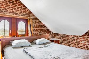 a bedroom with a bed and a brick wall at Beautiful mansion with swimming pool in Bilzen