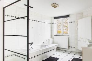 a white bathroom with a tub and a toilet at Beautiful mansion with swimming pool in Bilzen