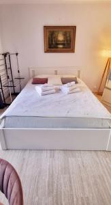 1 dormitorio con 1 cama blanca grande y toallas. en Central Monaco Studio, en Montecarlo