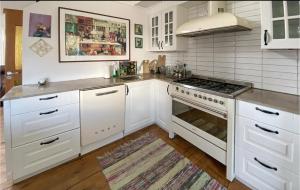 a kitchen with white cabinets and a stove top oven at maggies sea lodge in Gothenburg