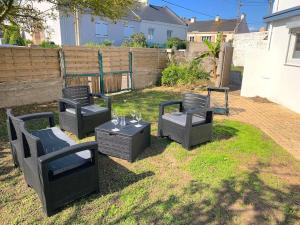 a group of chairs and tables in a yard at Le Marco Yourhosthelper Conciergerie in Lorient