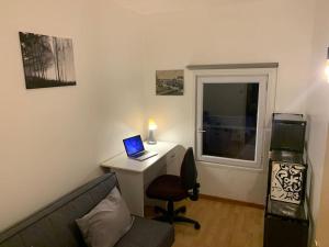 a living room with a desk with a laptop on it at Le Marco Yourhosthelper Conciergerie in Lorient
