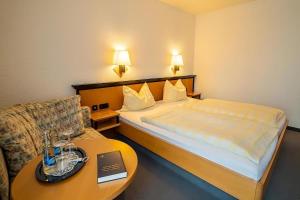 Piccola camera d'albergo con letto e tavolo di Hotel Zur alten Schmiede a Schaprode