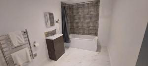 uma casa de banho com uma banheira, um lavatório e um chuveiro em Hatfield Lodge em Lowestoft