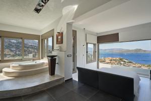 a bathroom with a tub and a sink with a view at Elounda Black Pearl Villa in Agios Nikolaos