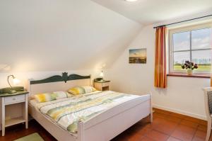 a bedroom with a bed and a window at Ostfriesland in Krummhörn