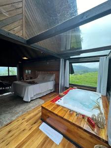 1 dormitorio con cama y ventana grande en Maria Rita dos Canyons, en Praia Grande