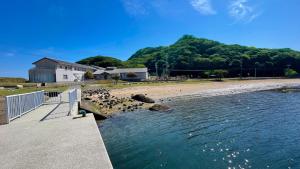 une plage avec un bâtiment et l'eau dans l'établissement エトワール生石, à Yura