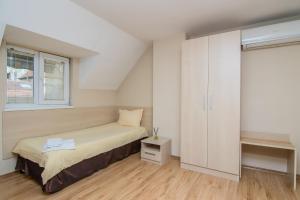 Habitación pequeña con cama y ventana en Family Hotel Madrid en Sofía