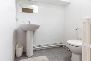 a white bathroom with a sink and a toilet at Maison Briand - Petite chambre chez l'habitant - Melun Centre - Wifi, Netflix, Smart TV, Lit à mousse mémoire de forme in Melun