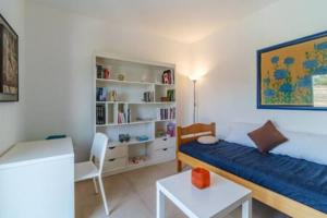 a bedroom with a bed and a chair and a book shelf at Villa Ameli in Milna