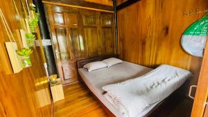 Habitación pequeña con cama en una habitación de madera en Homestay Yến Long en Lạng Sơn