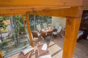 eine Holzterrasse mit einem Tisch und Stühlen darauf in der Unterkunft Seaside Penthouse HighLife in Ivan Dolac