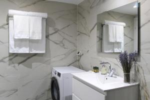 a bathroom with a washing machine and a sink at Luxury Suite Apartment #1 By Hashdera Eilat in Eilat +15 photos