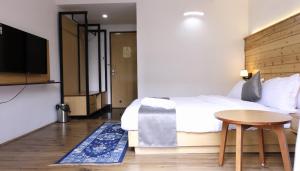 a bedroom with a bed and a table and a tv at Hotel Sernya - M.G.Marg in Gangtok