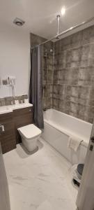 a bathroom with a toilet and a tub and a sink at Hatfield Lodge in Lowestoft