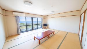 a living room with a table and a large window at エトワール生石 in Yura
