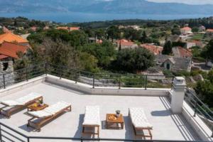 a patio with lounge chairs and tables on a balcony at Luxury Holiday House Skrip with Private Pool in Škrip