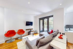 a living room with a couch and red chairs at 2Bed & 2Bath Flat w free parking, lift, balcony in London