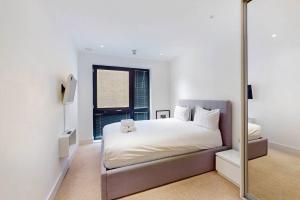 a bedroom with a large bed and a mirror at 2Bed & 2Bath Flat w free parking, lift, balcony in London